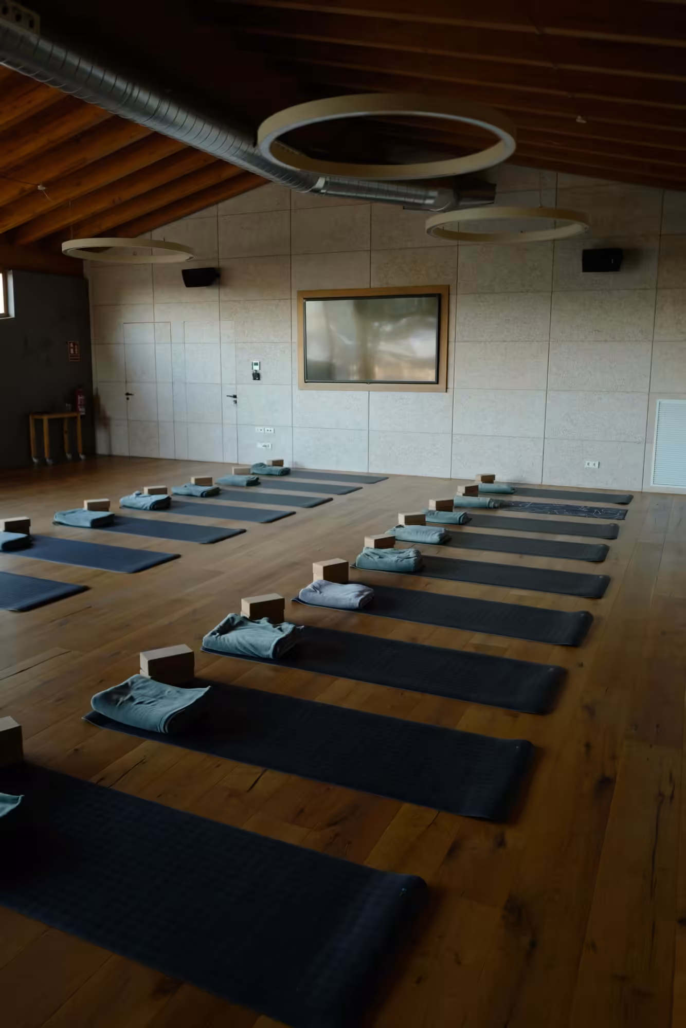 Yoga Studio mit Matten und Blöcken in Reihen auf Holzboden