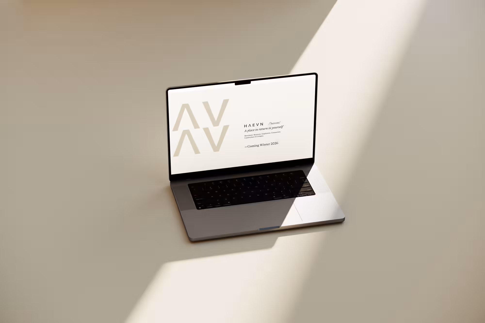 Laptop mit dem Webdesign eines Studios auf cremefarbenem Untergrund im Schattenspiel
