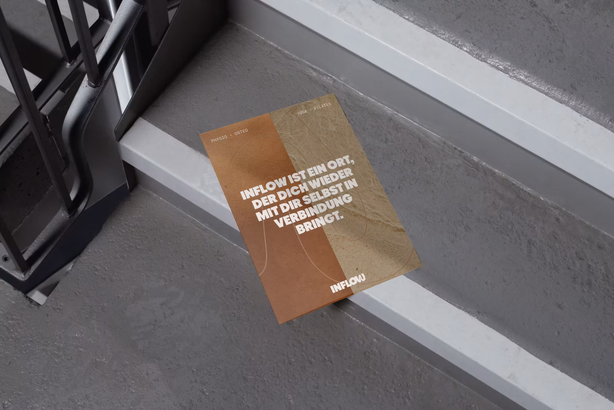 INFLOW-Flyer in Braun- und Sandtönen auf einer grauen Treppenstufe